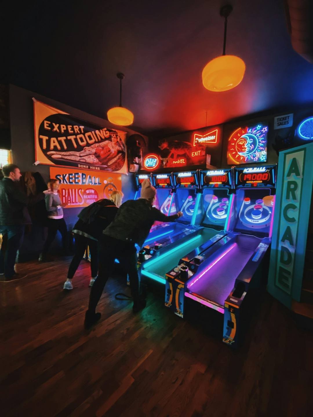People playing an arcade game in a dark room, unedited